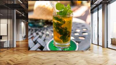 traditional cuban mojito glass served in crystal glass with mint on table with summer hat Wall mural