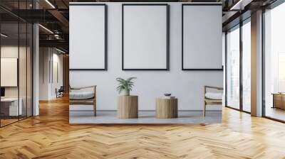 Three blank framed posters above two chairs with white cushions and two wooden side tables in a living room setting. Wall mural