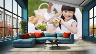 Happy young family having a picnic on the grass Wall mural