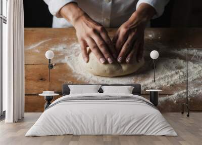 Baker kneading dough on rustic wooden table with copy space Wall mural