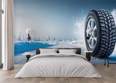 Winter tire moving on a snowy road in a winter landscape Wall mural