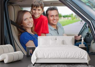 Family with one kid is travelling by car, smiling and looking at Wall mural