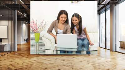 Mother and daughter with laptop. Cheerful daughter and mother wo Wall mural