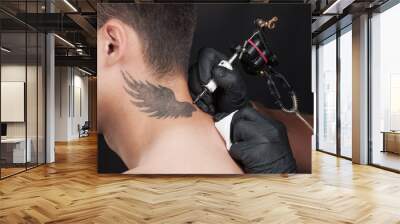 professional tattooist drawing beautiful wings. Wall mural