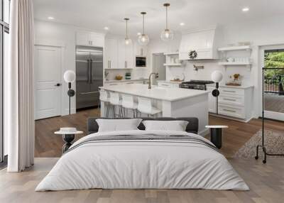 beautiful kitchen in new luxury home with island, pendant lights, hardwood floors, and stainless steel appliances Wall mural