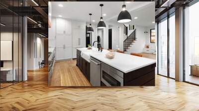 Beautiful white kitchen with dark accents in new modern farmhouse style luxury home. Features large island with farmhouse sink, dishwasher, microwave and view of living room and stairs. Wall mural