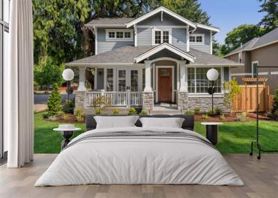 New luxury home exterior with covered porch and green grass on bright sunny day with blue sky Wall mural