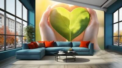 hands hold leave in green heart shape Wall mural