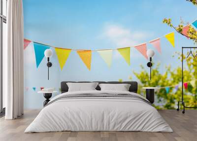 string of colorful pennant against blue sky in the garden as a summer party decoration Wall mural