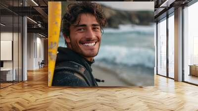 Portrait of young man with a surfboard at the beach, smiling brightly, capturing the joy and excitement of surfing and beach life. Wall mural