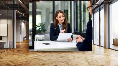 A businesswoman reading a cv of an ambitious man during the interview. Wall mural