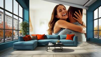 A close-up of a happy woman enjoying hugging her boyfriend at home. Wall mural