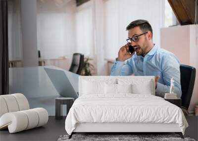 Angry businessman talking on the phone in office Wall mural