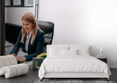 Beautiful blonde businesswoman typing on computer keyboard. Wall mural