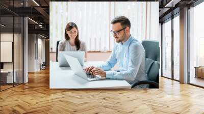 Business man and woman working on their computers. Wall mural