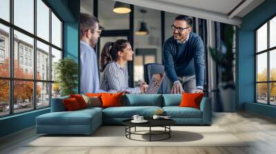 Business people, two males, and one female making a project together. Wall mural