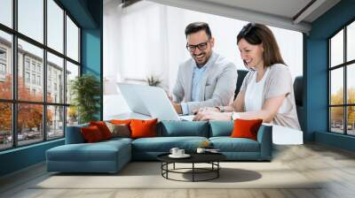 Businesspeople working together in bright office, sitting at desk. Wall mural