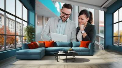 Cheerful business people discussing documents in office hall. Wall mural