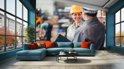 Coworkers talking and smiling at heavy industry factory, close-up. Wall mural