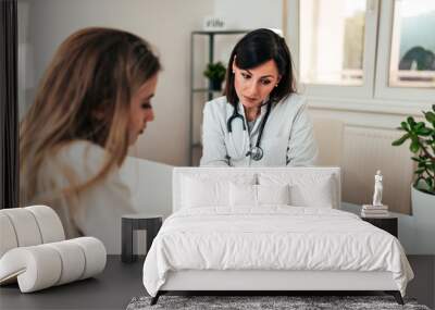 Doctor explaining diagnosis to her young female patient. Wall mural