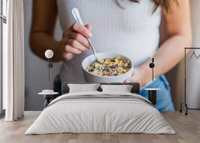 Eating healthy breakfast. Woman holding bowl of cereal. Close-up. Wall mural