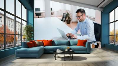 Entrepreneur working with a laptop in office Wall mural