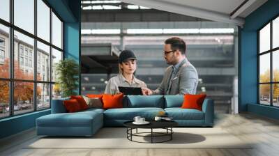 Executive manager talking to a female factory employee at manufacturing plant. Wall mural