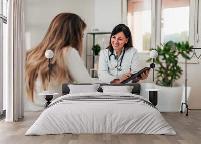 Female doctor explaining diagnosis to her young patient. Wall mural