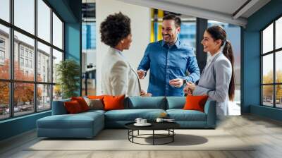 Happy office workers, joking around in the open space office of the company. Wall mural