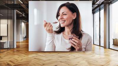 Happy woman eating pudding. Wall mural