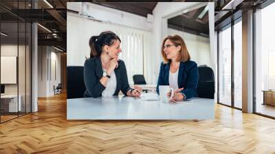 image of two business woman talking in bright office. Wall mural