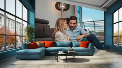 Loving couple at home enjoying time together, sitting on floor. Wall mural