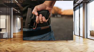 Man holding hidden short gun in his hand. Wall mural