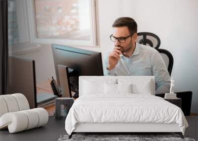 Man working on computer in modern office interior. Wall mural