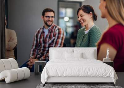 Photo of a smiling man and woman attending the group therapy, laughing together. Wall mural