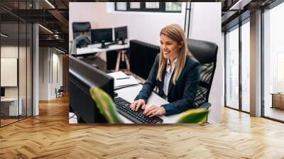 Portrait of a happy businesswoman working in the office. Wall mural