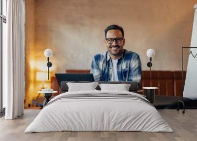 Portrait of a smiling businessman, posing for the camera while t Wall mural