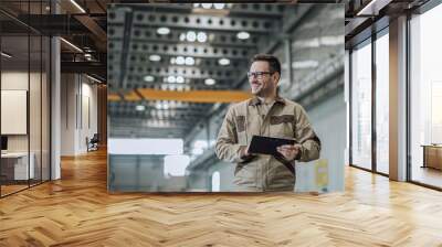 Portrait of a smiling foreman at work in industrial building. Wall mural