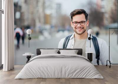 Portrait of a smiling student at the city street. Wall mural