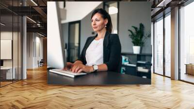 portrait of beautiful businesswoman working on computer in modern office. Wall mural