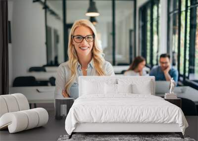 portrait of casual female leader. employees in the background. Wall mural