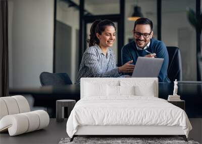 portrait of two business colleagues, looking at something online. Wall mural