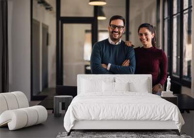 Portrait of two business persons leaned on the table, hands crossed. Wall mural