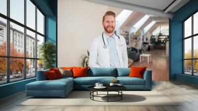 Portrait of young cheerful doctor in bright office. Wall mural