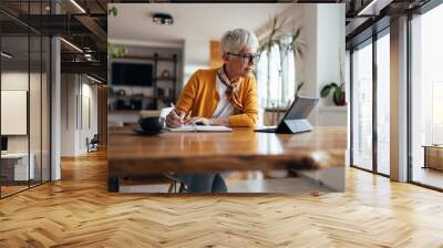 Senior businesswoman, working hard, from home office. Wall mural