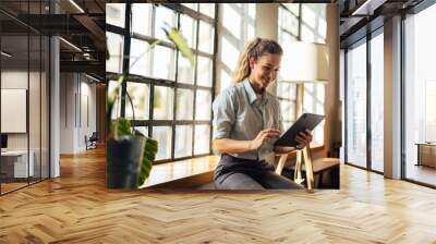 Smiling business girl, doing her work, being at the workplace, using a tablet. Wall mural