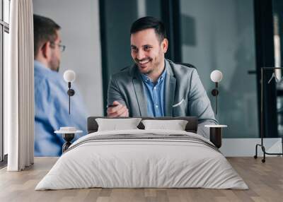 Smiling businessman giving pen to a client for signing a contract. Wall mural