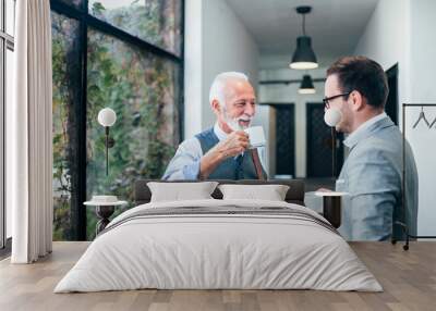 Smiling senior and young business men on a coffee break. Wall mural