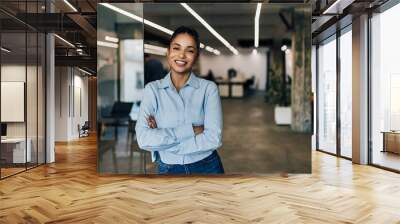 Smilling businesswoman standing at the office,looking at the camera. Wall mural