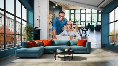 Successful startup business. Portrait of two young smiling people at work in modern office. Wall mural